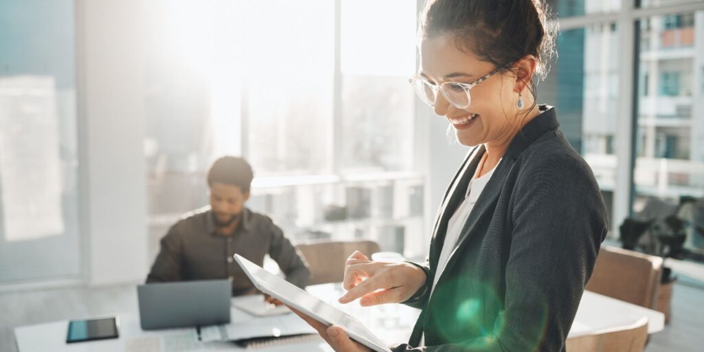 Happy business woman looking at tablet.