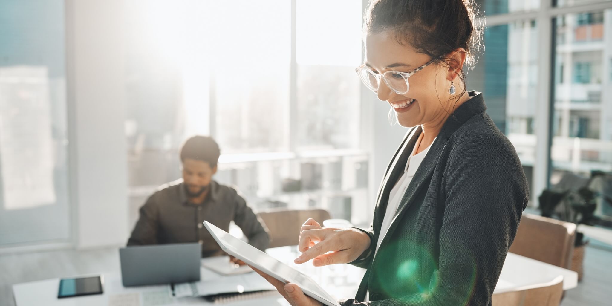 Happy business woman looking at tablet.